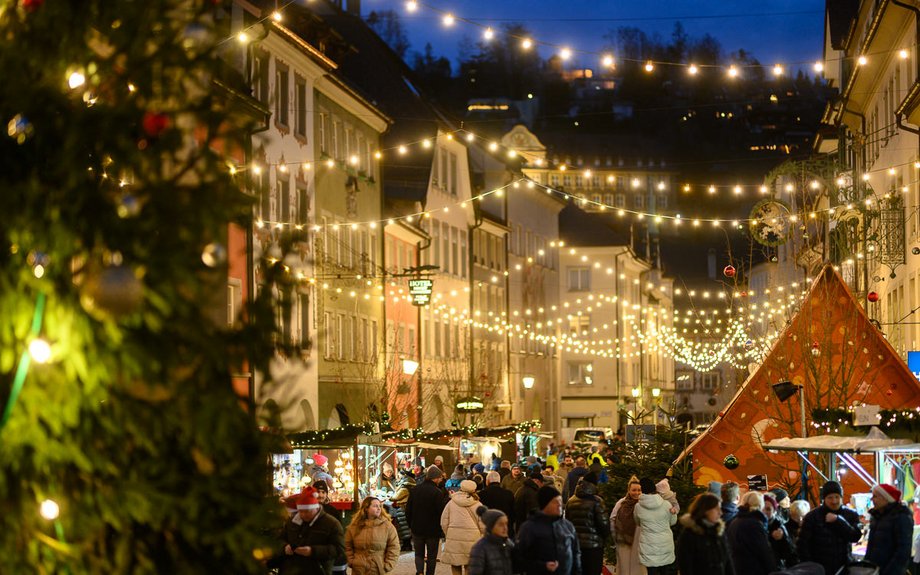 Eine schön beleuchtete Stadt am Abend, viele Menschen sind unterwegs
