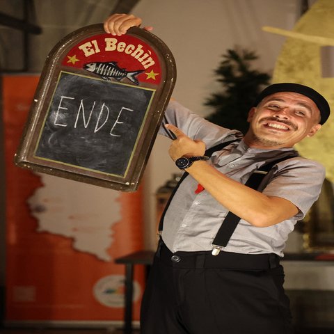 Ein Straßenkünstler zeigt ein Schild mit "Ende"