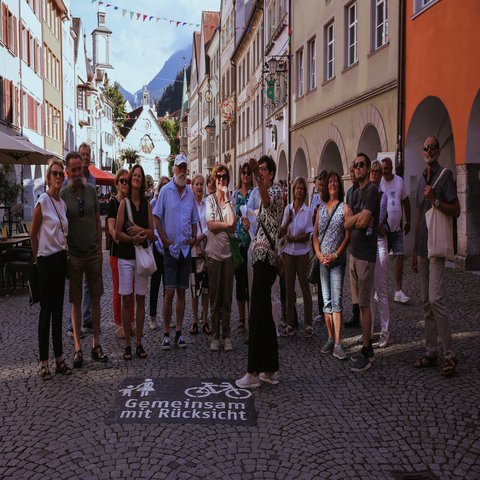 Eine Gruppe an Menschen steht in einer Stadt