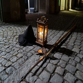 Auf Pflastersteinen liegt ein Hut und eine Laterne