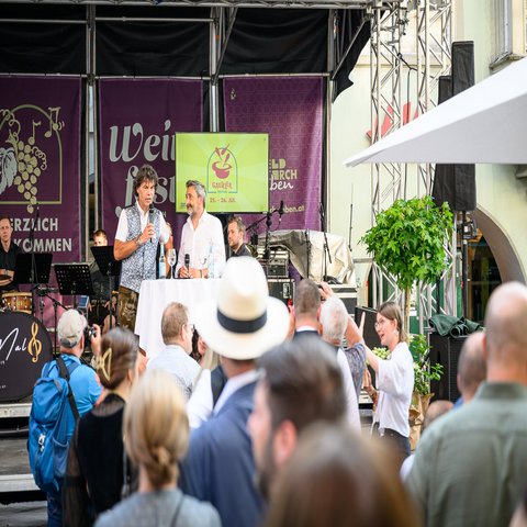 Zwei Männer auf der Bühne vor Publikum