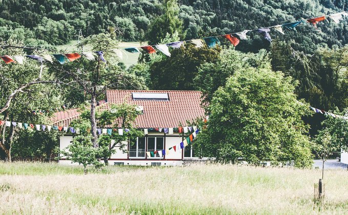 Ein Haus in einem Feld, überall sind Flaggen aufgehängt