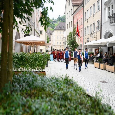 Musikanten marschieren in einer Gasse einer Stadt