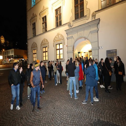 Mehrere stehen vor einem Gebäude