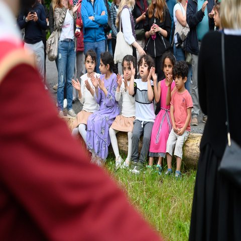 Kleine Kinder auf einer Bank, alle klatschen
