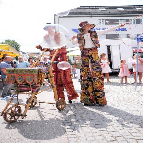 Männer auf Stälzen mit Seifenblasen