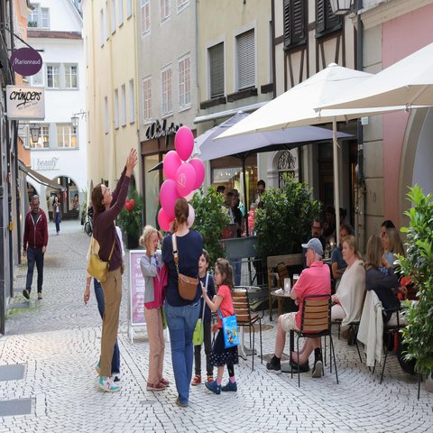 Menschen stehen in einer Gasse einer Stadt