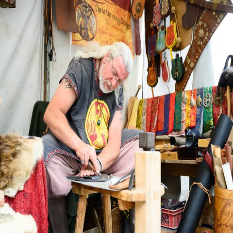 Ein Mann in mittelalterlicher Kleidung geht seinem Handwerk nach