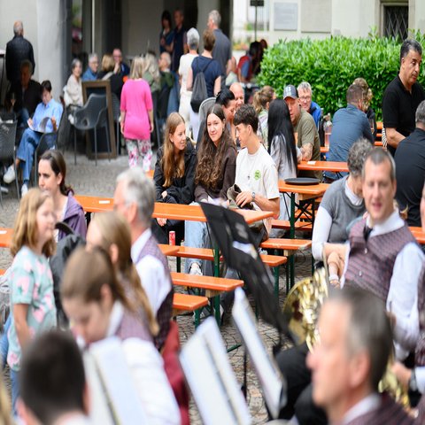 Mehrere Personen sitzen an Bierbänken