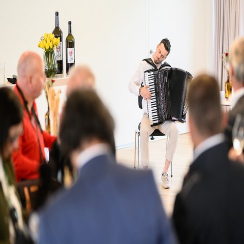 Ein Mann spielt Handorgel vor dem Publikum