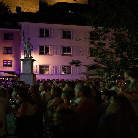 Eine Menschenmenge steht vor einem Haus
