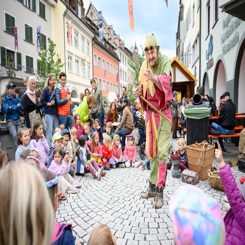 Ein Gaukler steht in der Mitte des Publikums