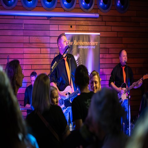 Zwei Männer singen auf einer Bühne vor Publikum